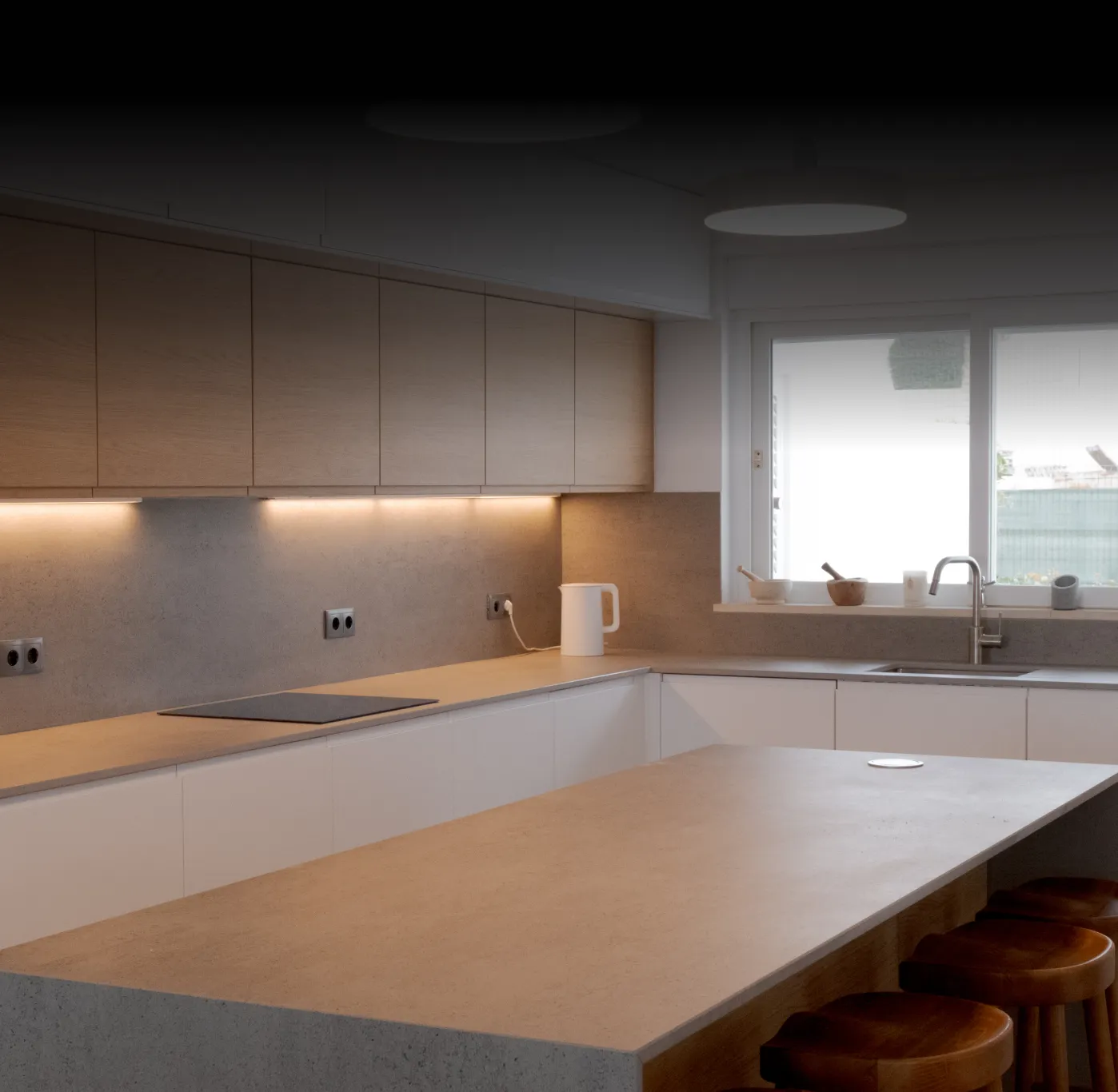 Modern kitchen interior with wood and stone finishes, minimalist cabinets, and large central island.