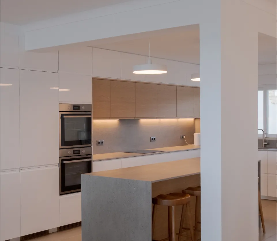 Bright renovated living space with clean white walls, sliding glass doors, and modern artwork on the wall.