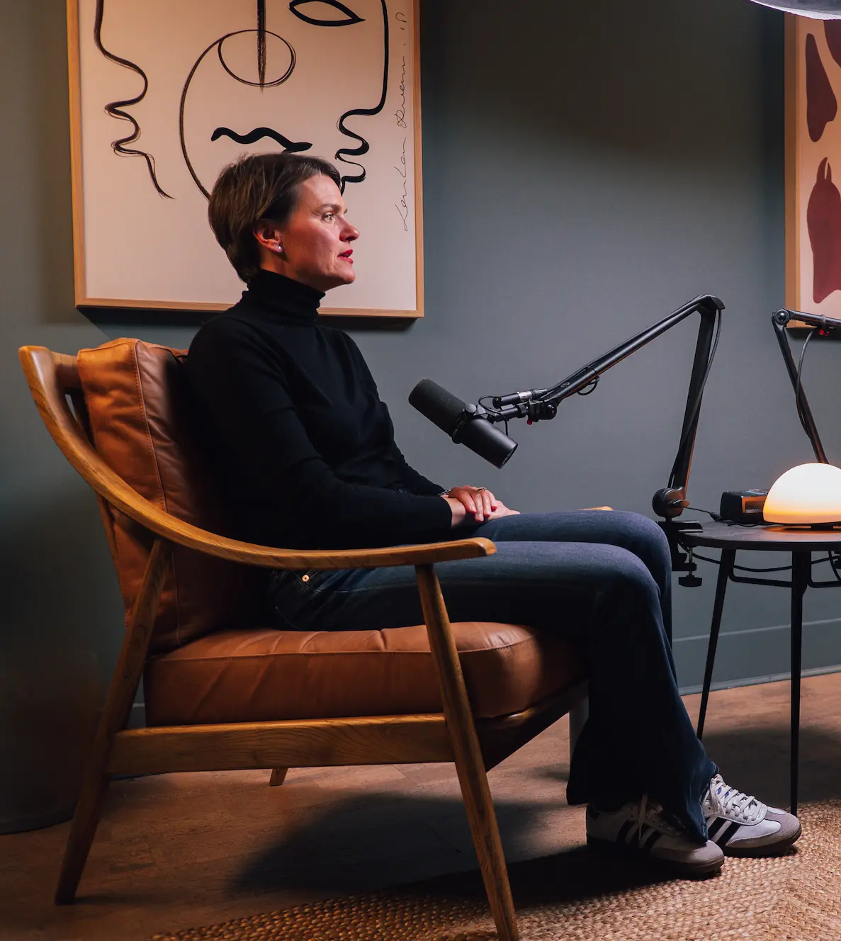 A woman sitting in a chair in front of a microphone.