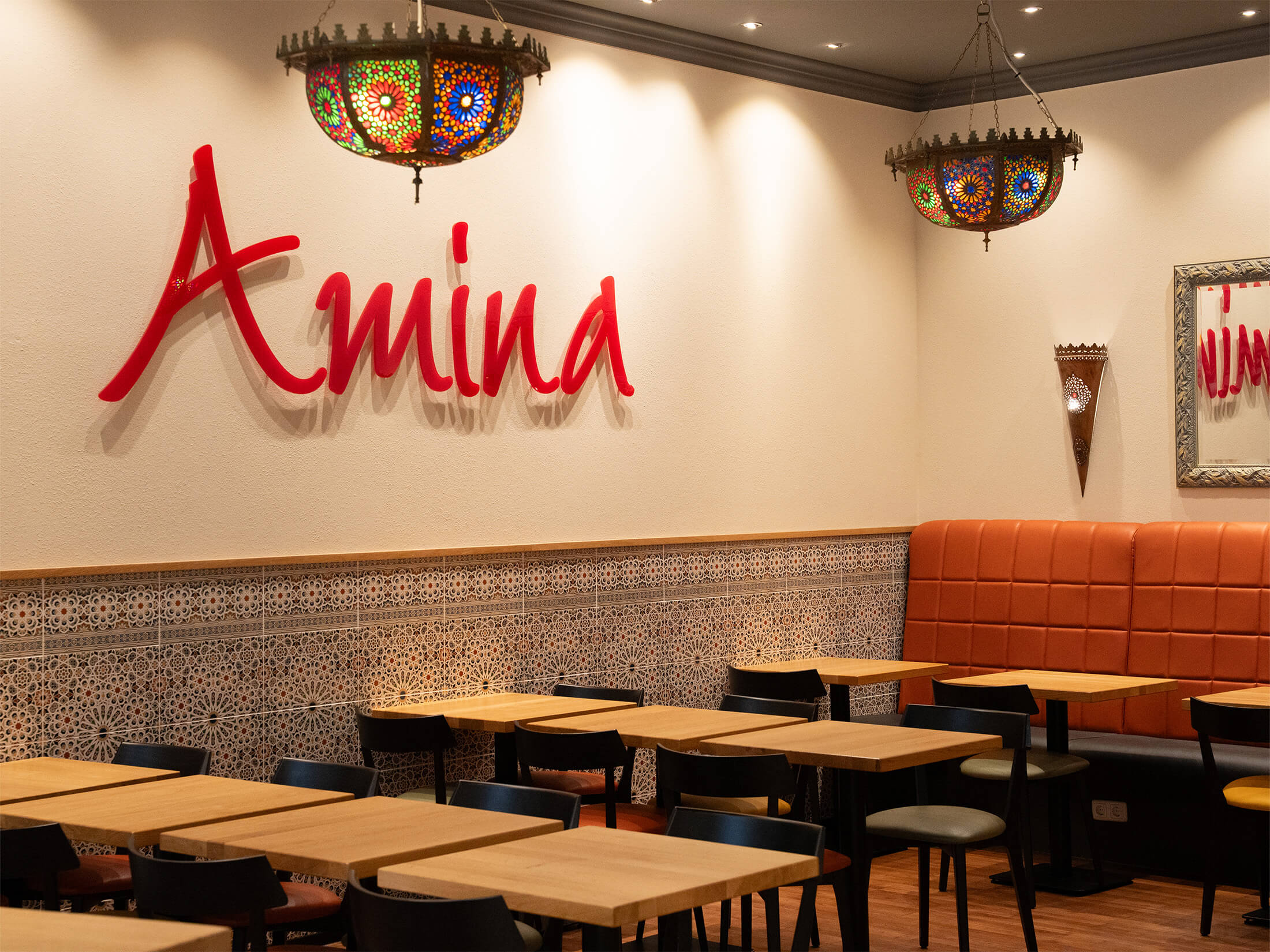 Ein stilvoll eingerichteter Sitzbereich mit Mosaikfliesen und warmem Licht bei Amina.