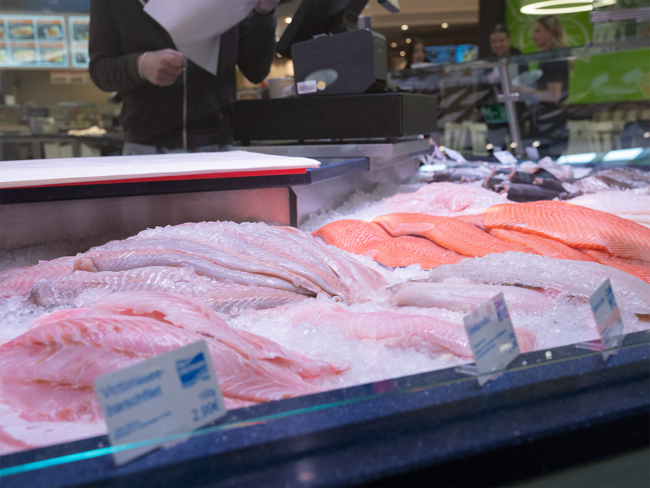 Frische Lachsfilets und weitere Fischspezialitäten auf Eis präsentiert.