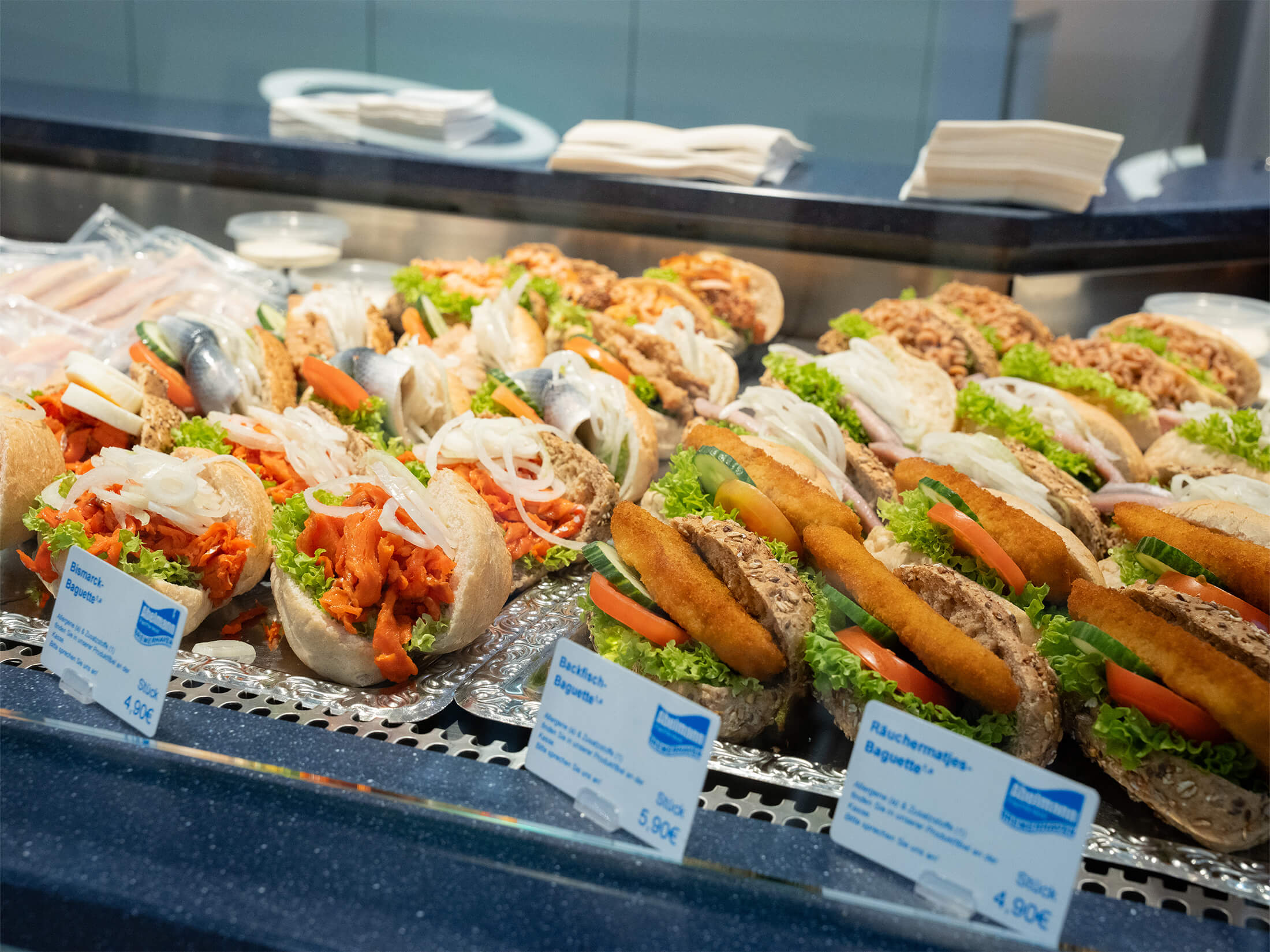 Große Auswahl an verschiedenen belegten Fischbrötchen in der Kühltheke.