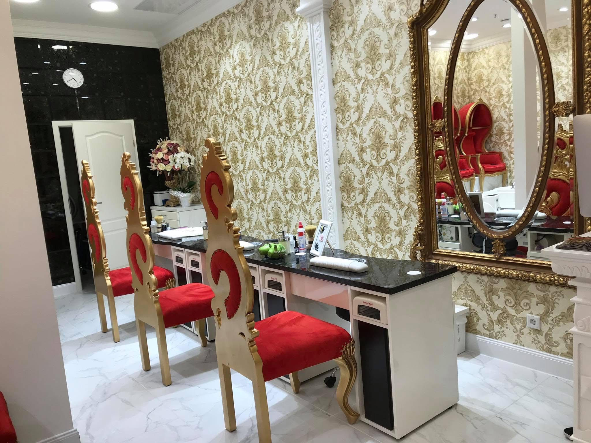 Detailansicht der Maniküre-Station mit großem goldenen Spiegel und rotem Stuhl im BeautyWorld Salon