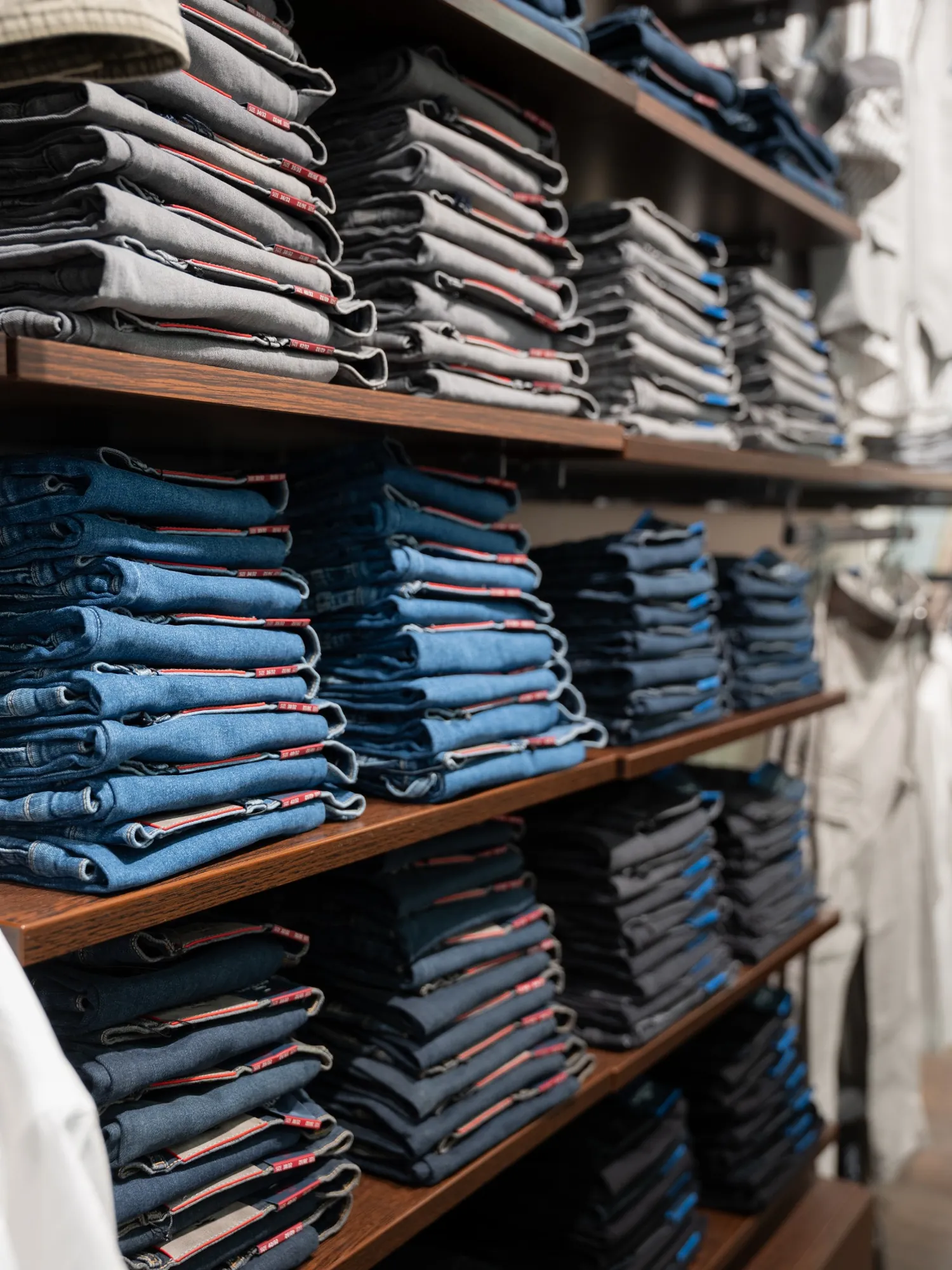 Regale mit ordentlich gefalteten Jeans in verschiedenen Waschungen im Engbers Store