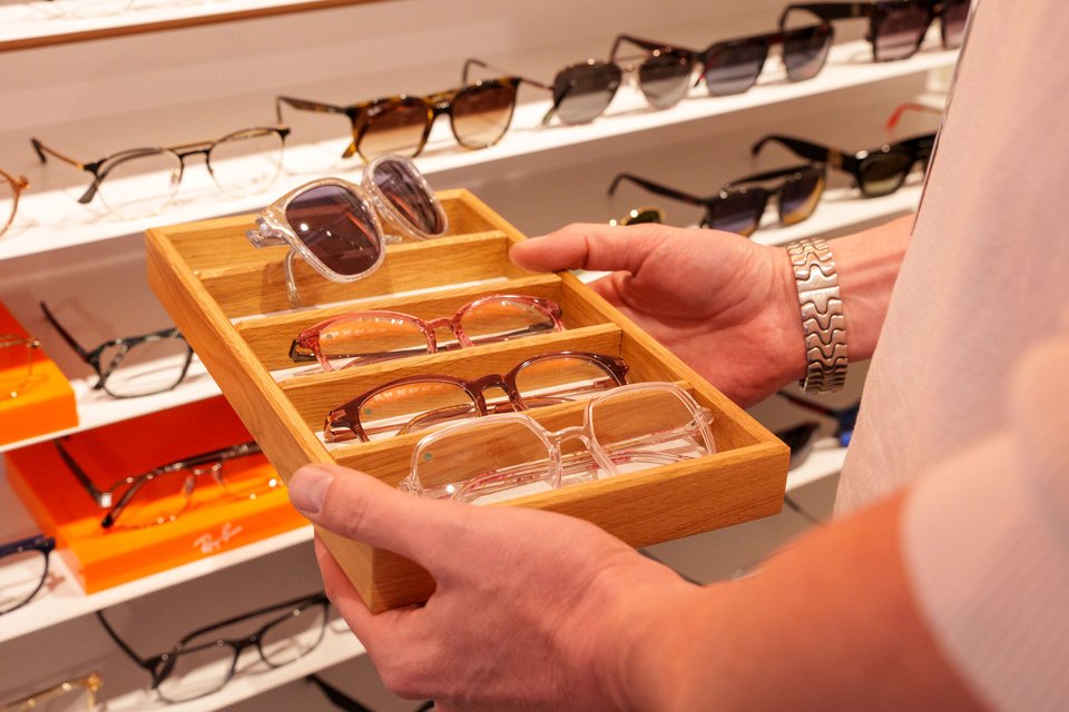 Empfangsbereich bei eyes + more mit Infotafel „Trau deinen Augen“ und Blick in den Sehtest-Raum.