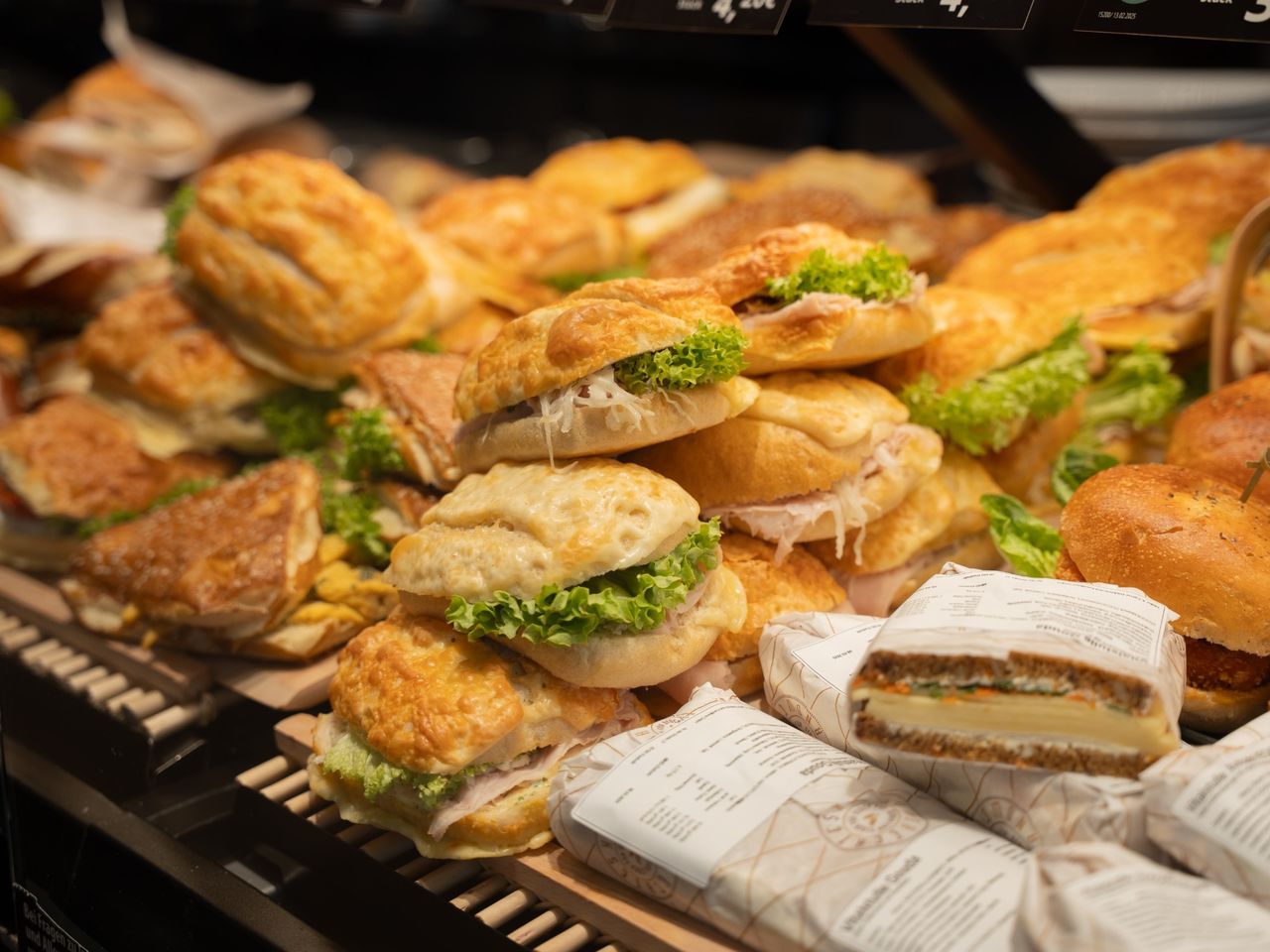 Verkaufsszene an der Kuchentheke mit Mitarbeiterin in der Bäckerei Müller & Egerer