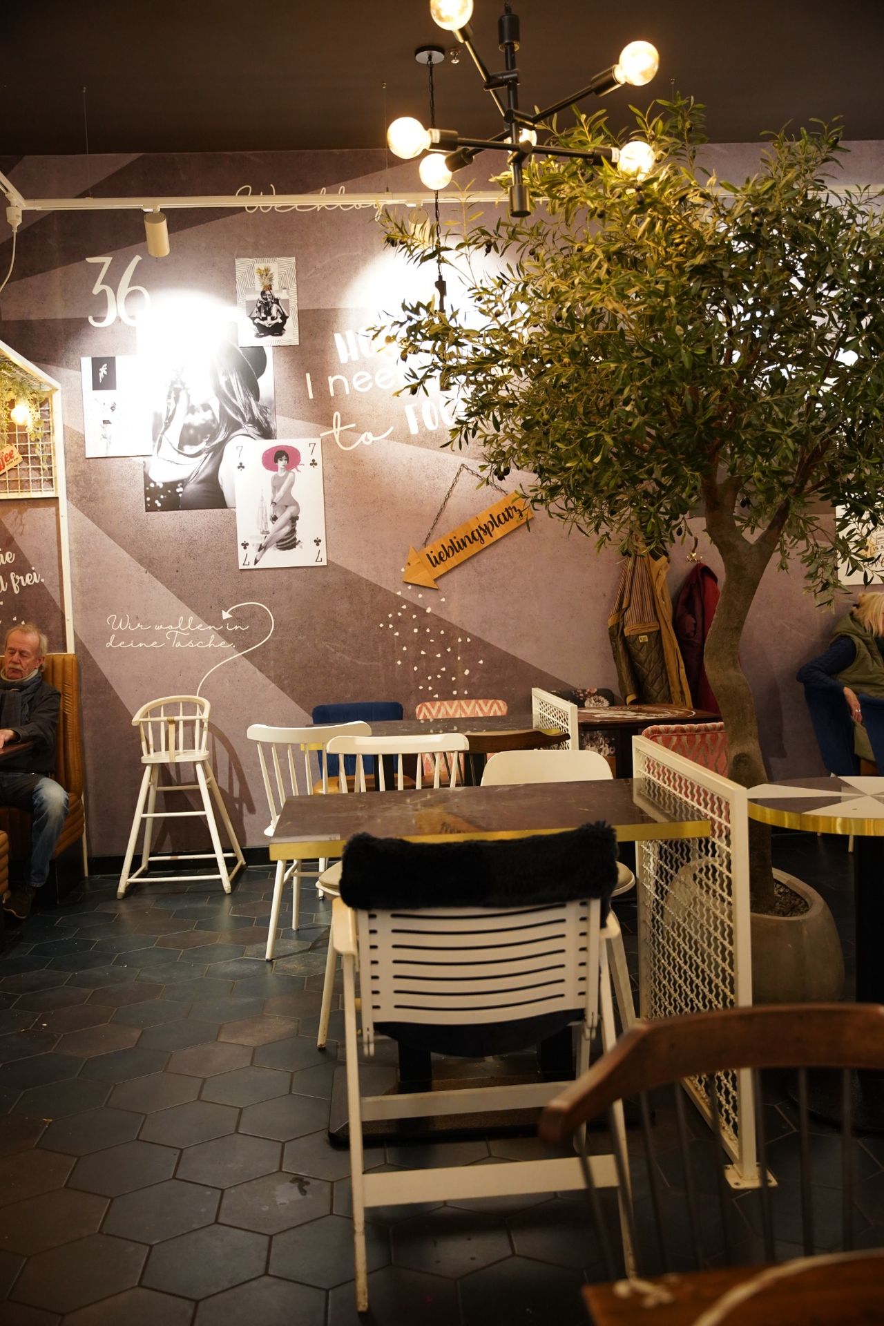 emütliche Sitzecke im Cafébereich von Müller & Egerer mit Wanddeko und Baum