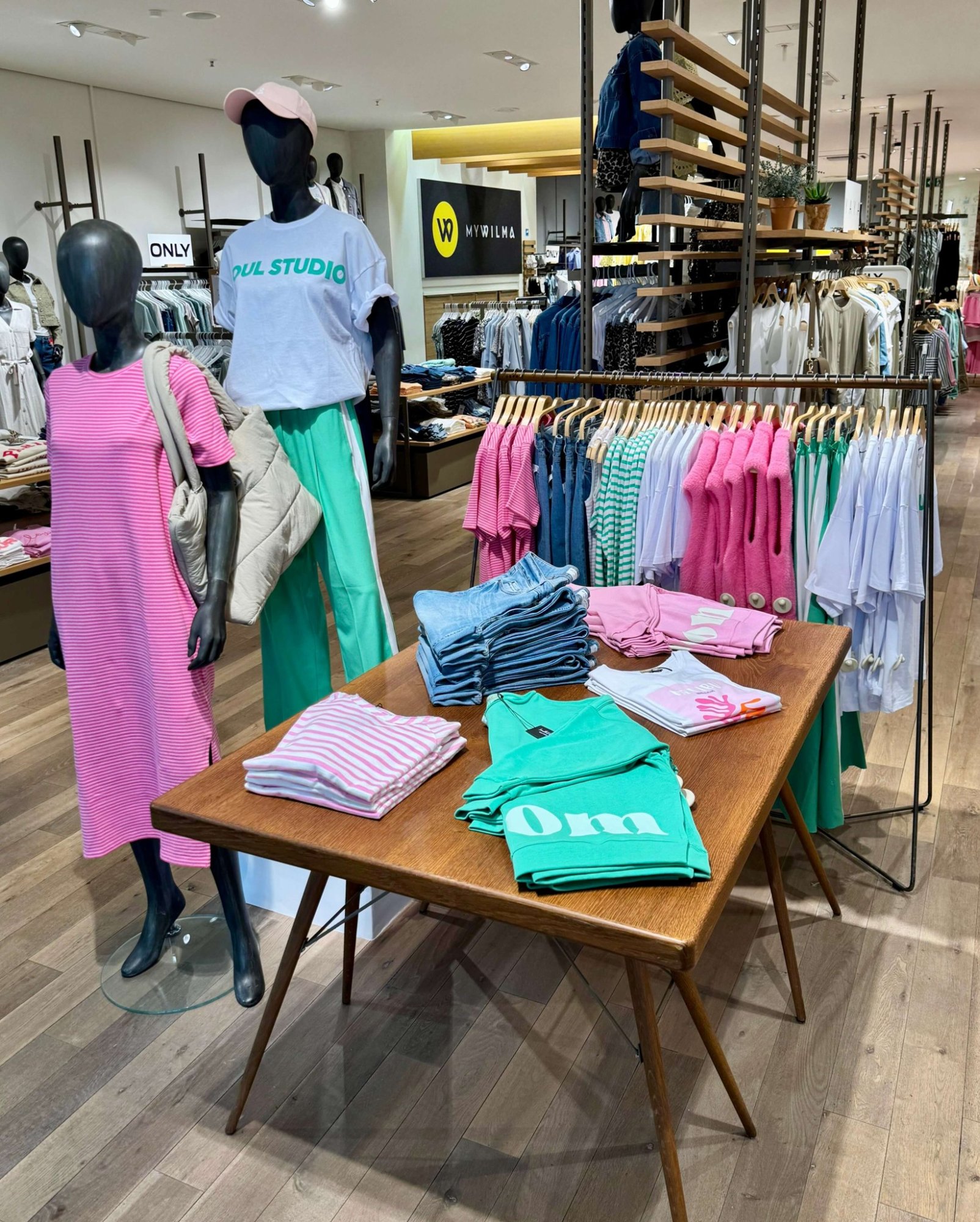 MYWILMA Verkaufsfläche mit angesagter Damenmode in leuchtenden Farben auf Präsentationstisch