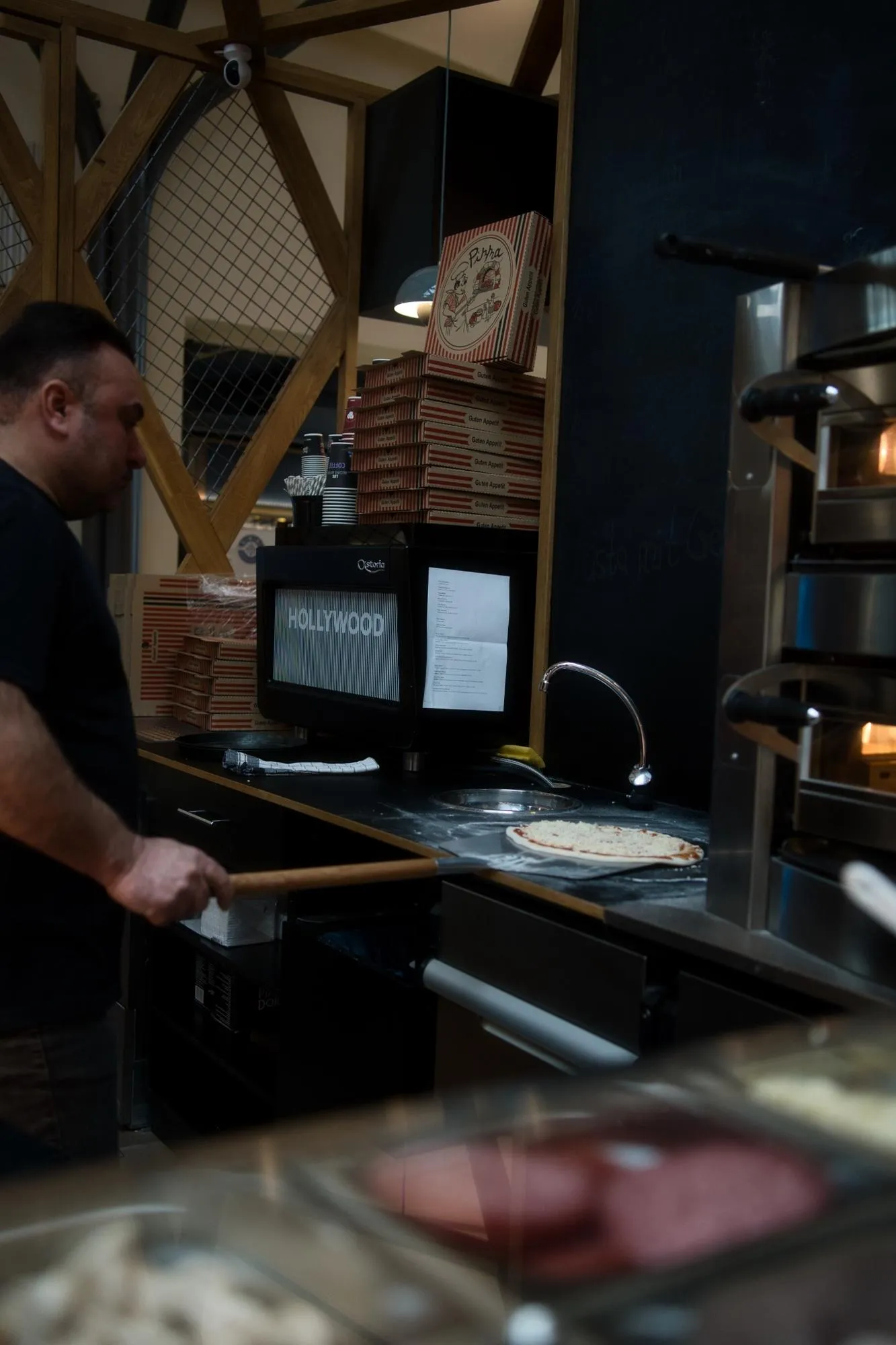 Pizzabäcker bereitet eine Pizza vor dem Ofen im Restaurant Rimini vor.