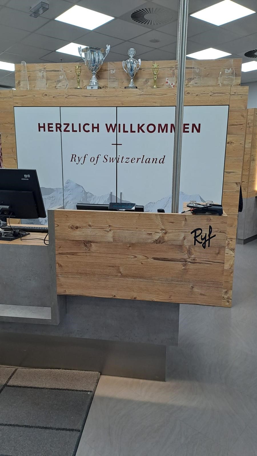 Empfangsbereich des Ryf of Switzerland Salons mit Auszeichnungen und Herzlich-Willkommen-Schild.