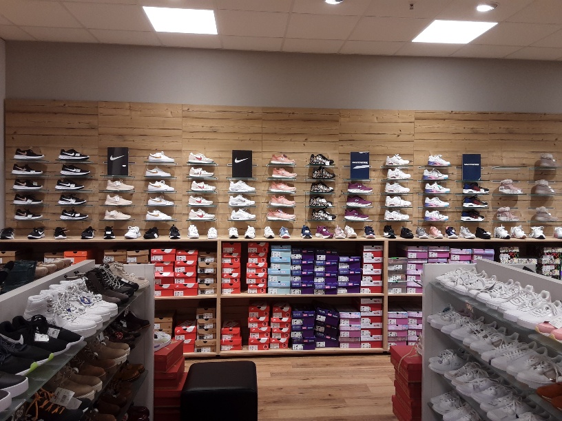 Sneakerwand mit vielfältiger Auswahl und Markenschuhkartons darunter