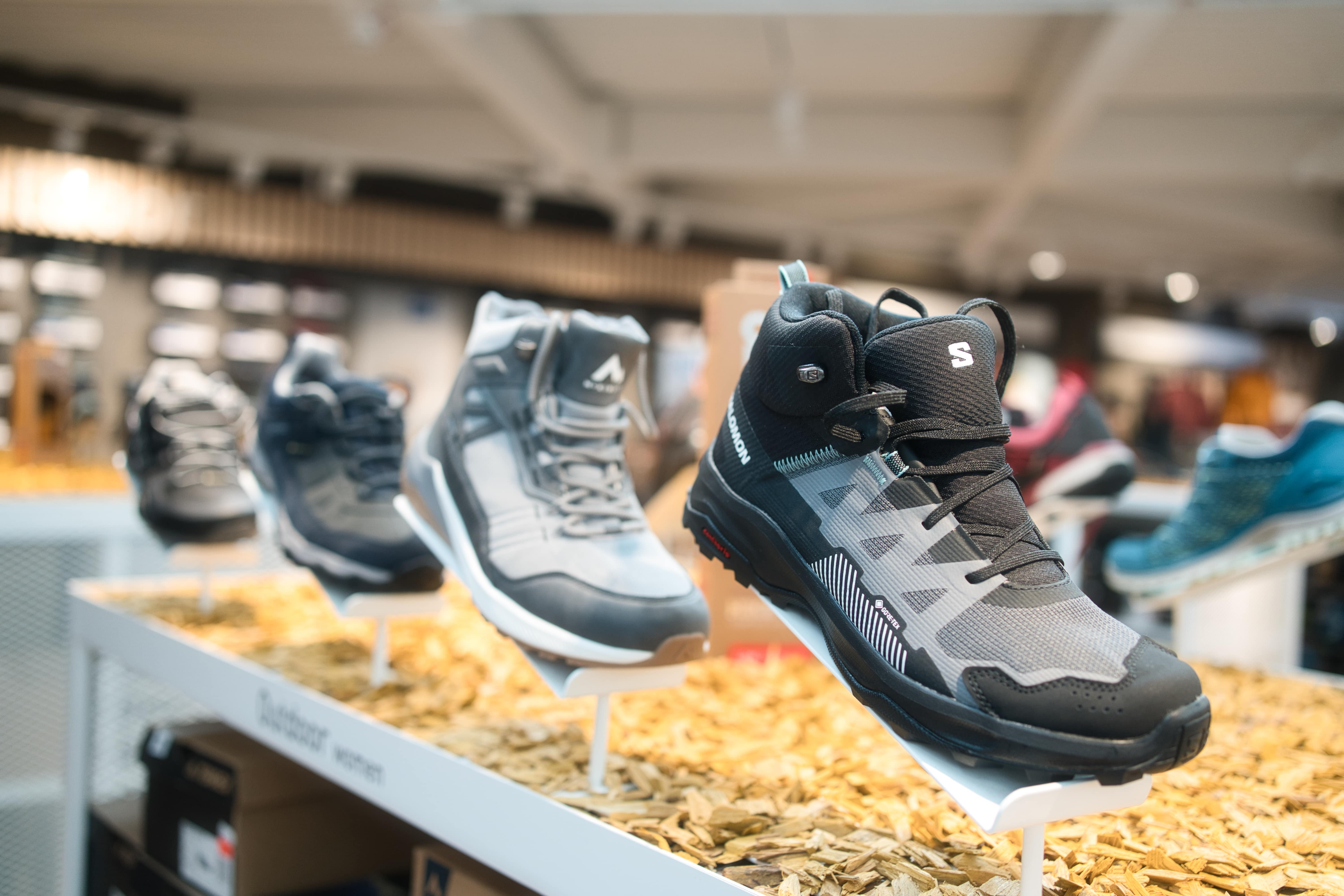 Verschiedene Wanderschuhe auf einem Schuhregal drapiert