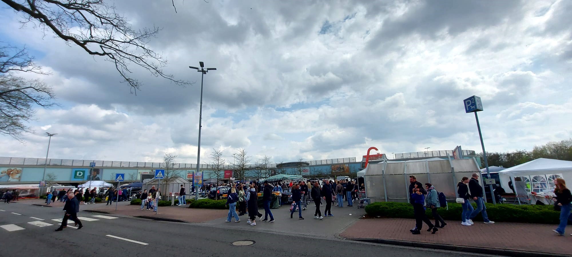 Viele Menschen sind zu sehen, wie sie durch die Gänge auf dem Flohmarkt laufen.