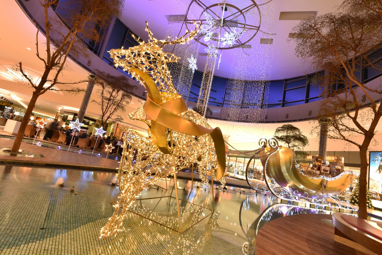 Zu sehen ist ein goldener Elch mit Schlitten in einem Brunnen.