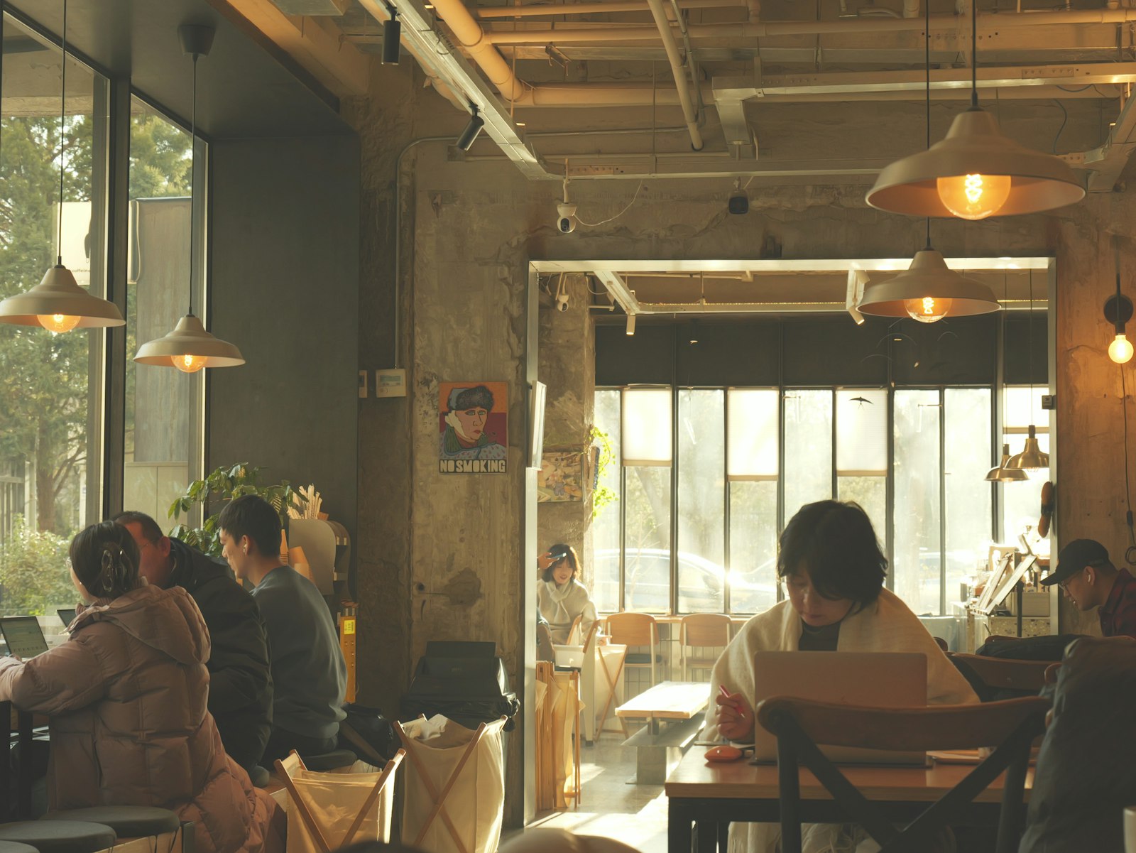 Intérieur de café lumineux où plusieurs personnes travaillent sur leur ordinateur portable