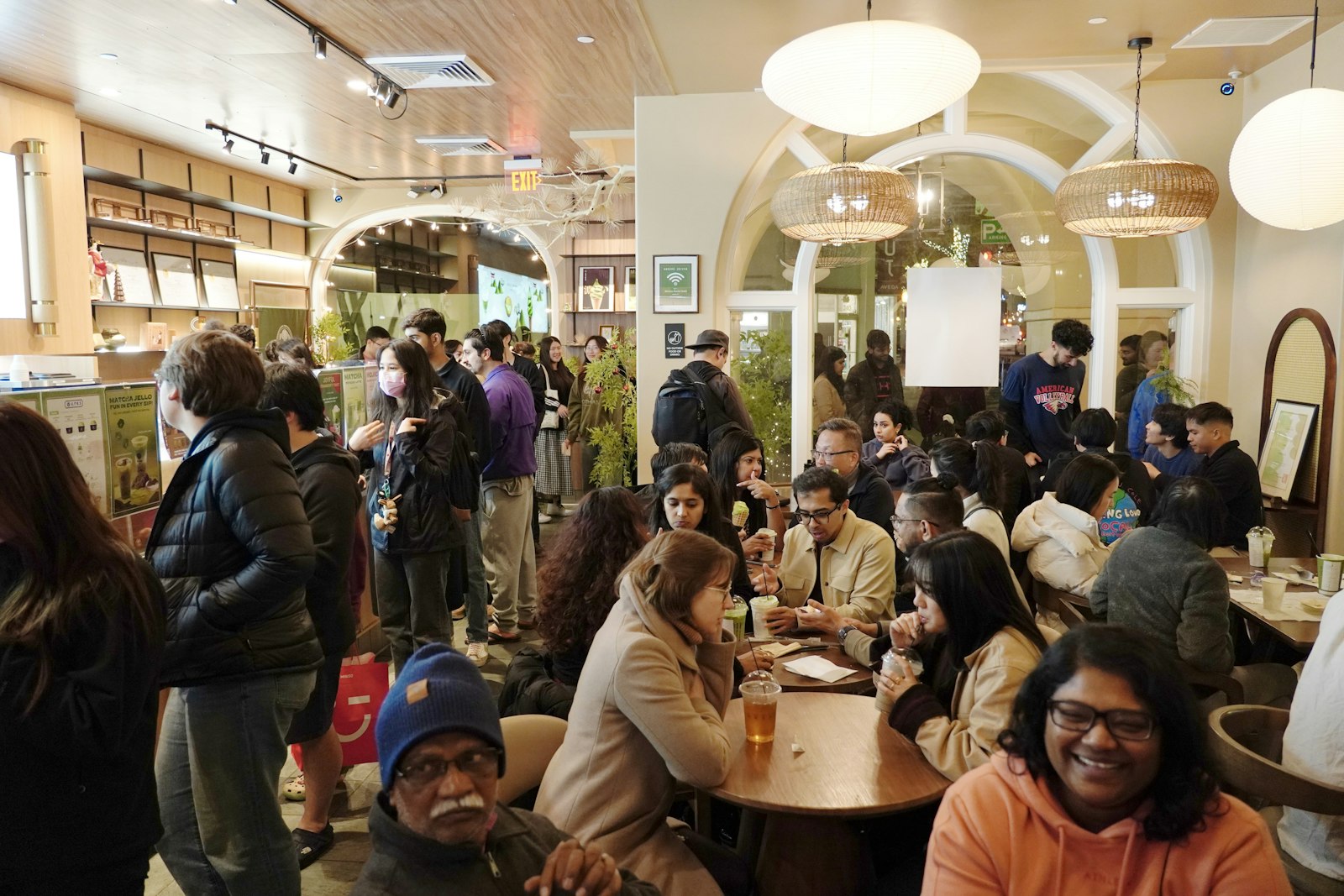 Intérieur animé d'un café bondé, clients attablés et bruit ambiant