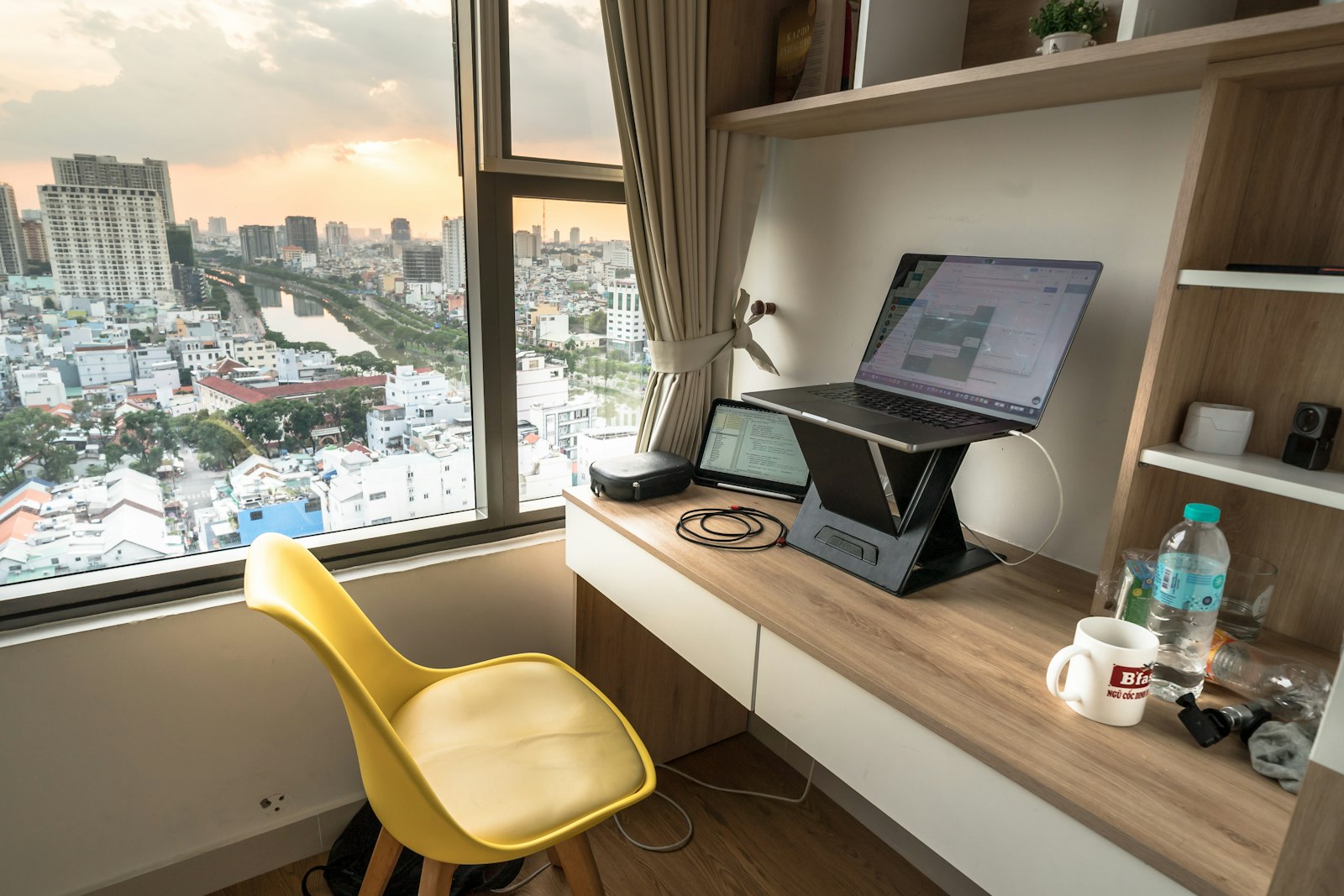 Bureau avec ordinateur portable et vue sur la ville au crépuscule