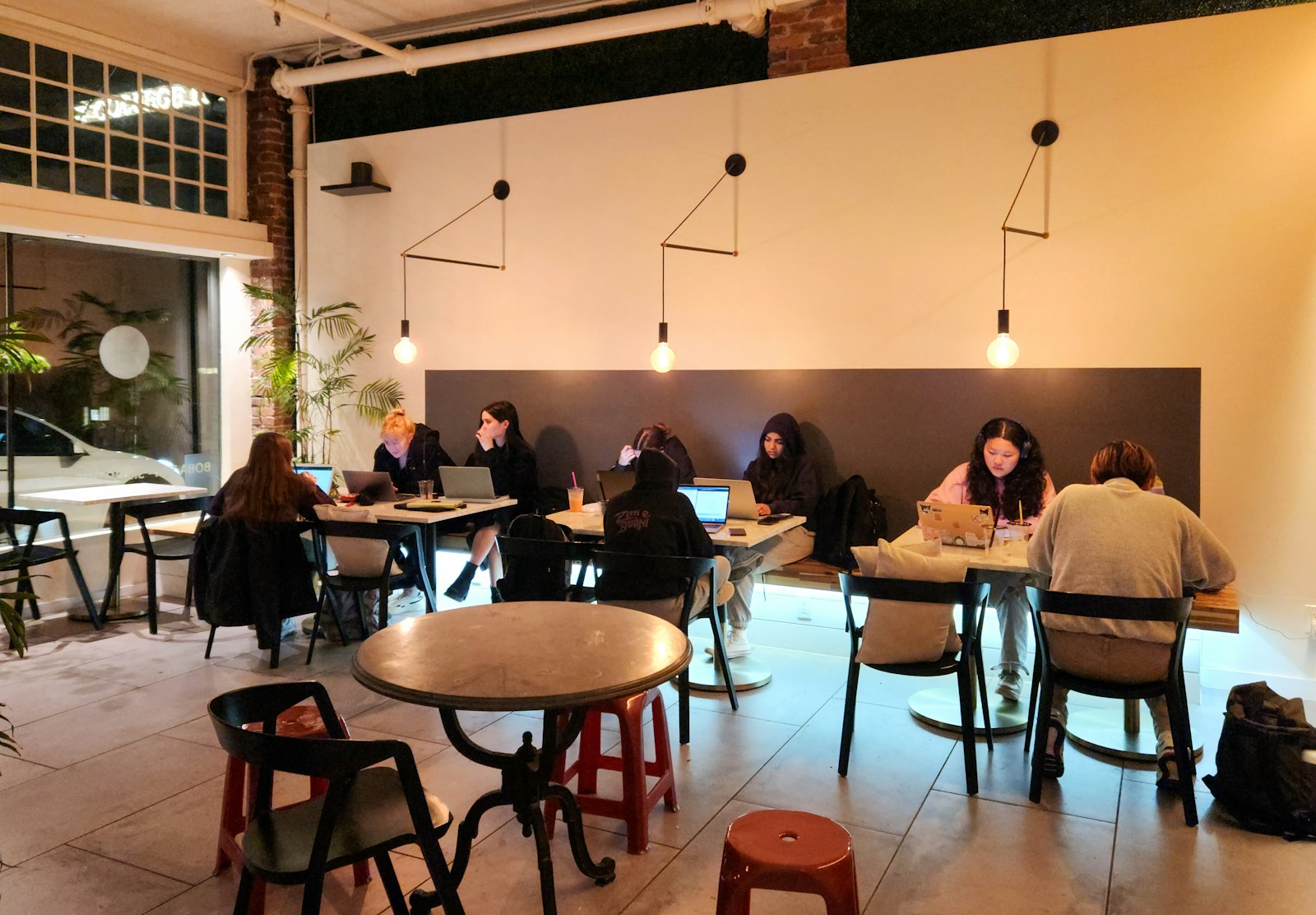 Personnes en train de travailler sur leur ordinateur portable dans un café chaleureux