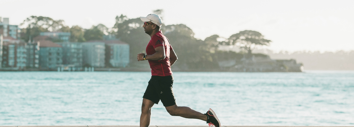Active man running outdoors near a waterfront, representing improved energy, fat loss, and vitality achieved through Gameday Men’s Health’s personalized treatment plans.
