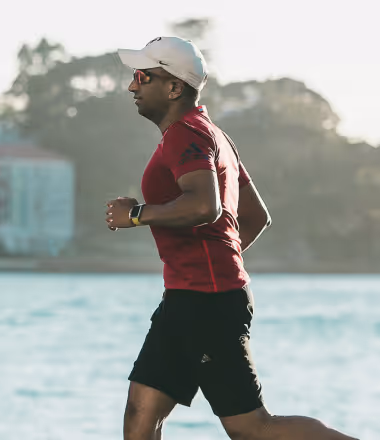 Man jogging outdoors in a red shirt, representing the energy, stamina, and overall vitality benefits of optimized testosterone health through Gameday Men’s Health.