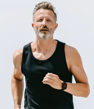 Fit middle-aged man jogging in athletic wear, representing the energy and confidence benefits associated with Gameday Men’s Health medical weight loss solutions.