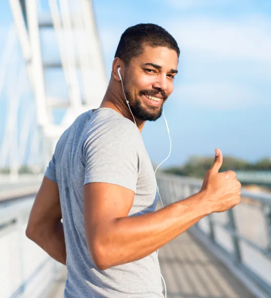 A man walking with headphones, radiating self-assurance thanks to ED treatment