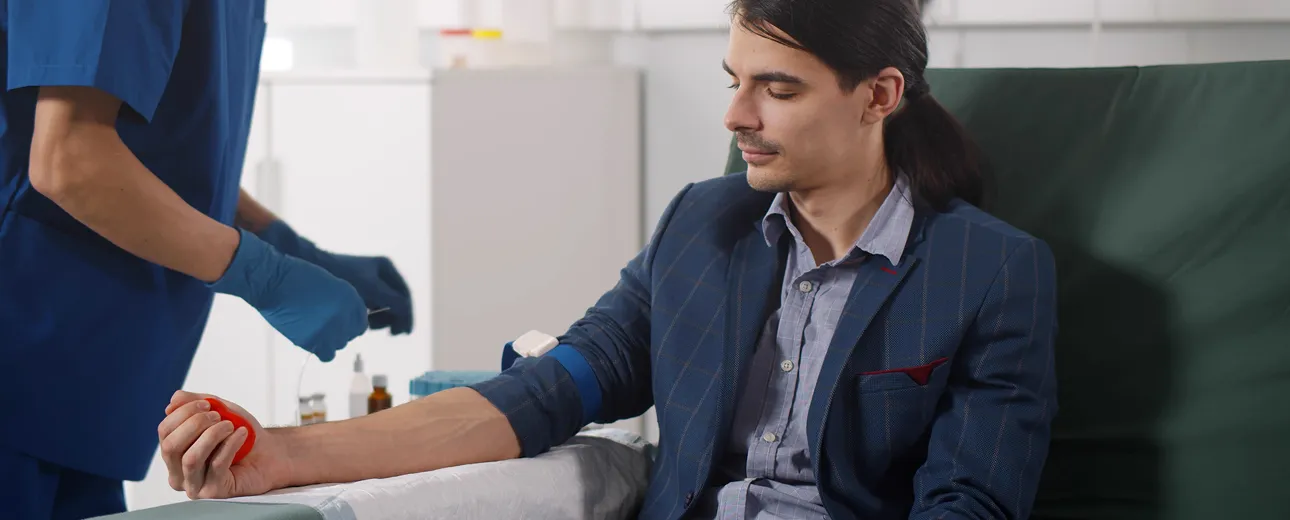 Man smiling while receiving IV therapy, representing wellness and relaxation.