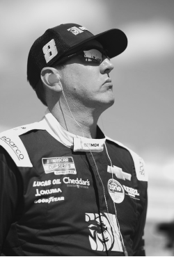 Black and white image of professional race car driver Kyle Busch wearing sunglasses and a racing suit, featured as a Gameday Men's Health influencer.