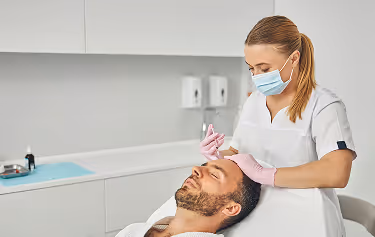 Female medical professional administering PRP injection on a male patient to restore and prevent hair loss.