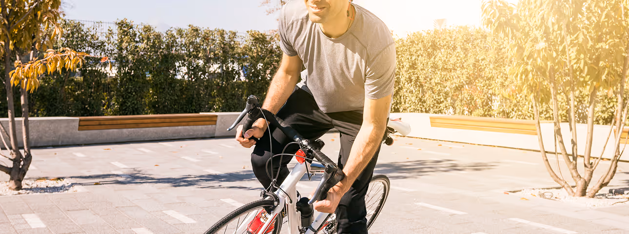 Man cycling outdoors with focus and energy, representing the active lifestyle benefits of testosterone replacement therapy.