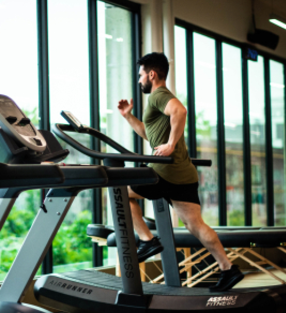 Man running on a treadmill, supported by testosterone pellet therapy to boost energy and stamina for better performance