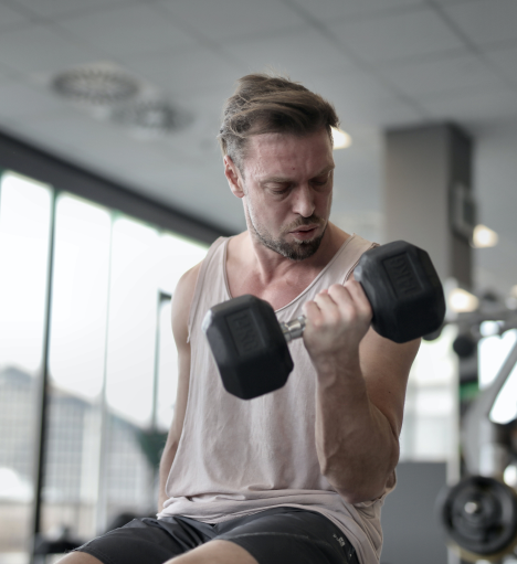 Fitness enthusiast working out with dumbbells, supported by testosterone pellet therapy for enhanced performance and muscle growth