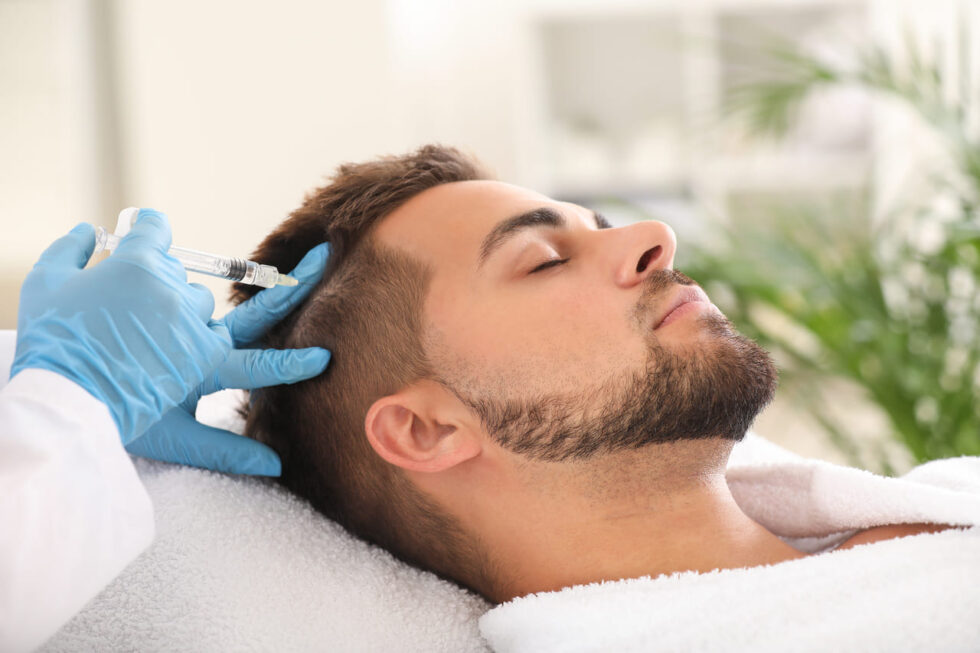 A man relaxing while receiving Botox treatment on his scalp in South Lexington