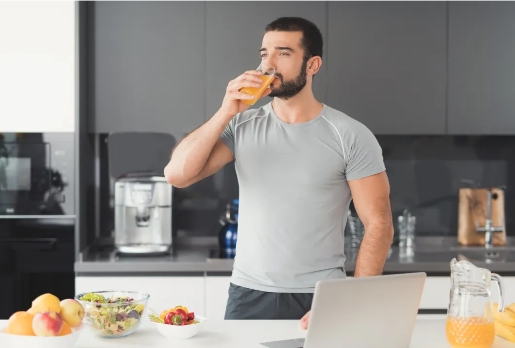 Man enjoying a healthy drink, supporting his weight loss journey with balanced nutrition and medical weight loss solutions