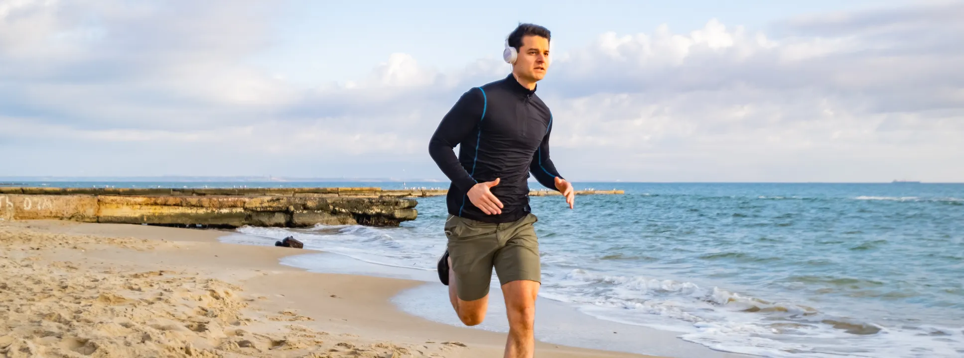 Man running along the beach, symbolizing improved vitality, confidence, and performance after P-Shot treatment.