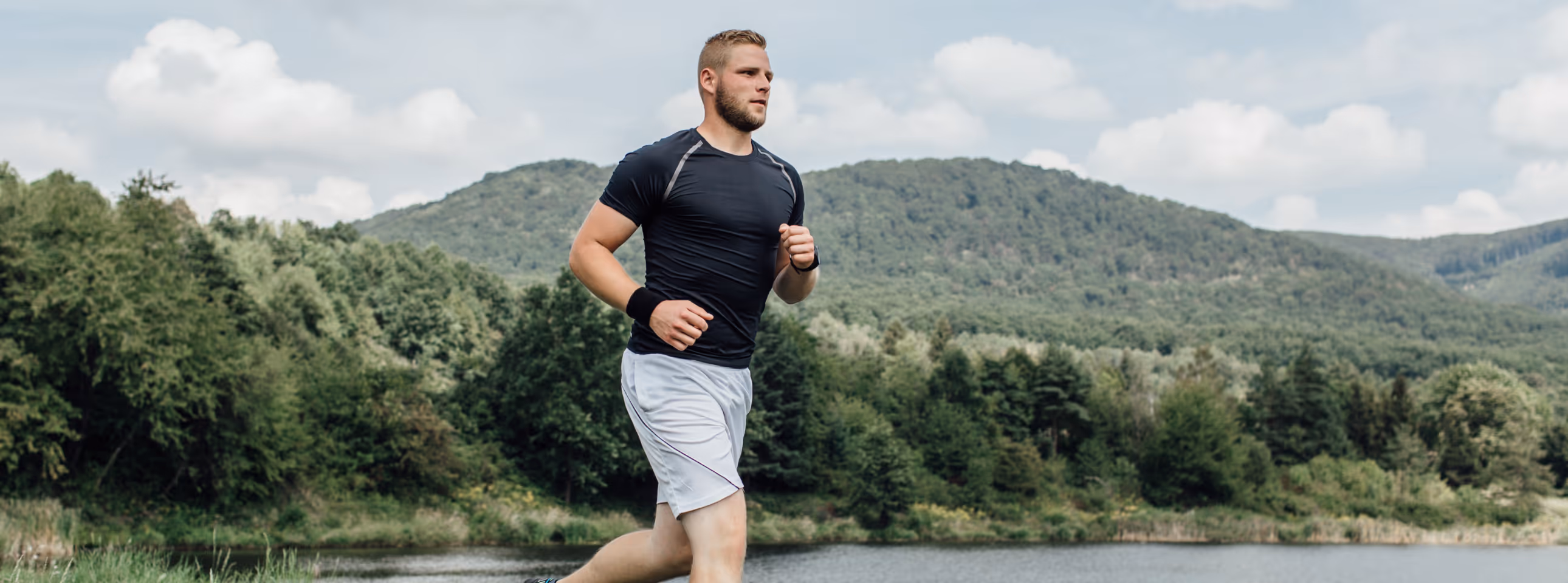 Athletic man running outdoors in the mountains, symbolizing stamina and vitality supported by Clomid therapy.