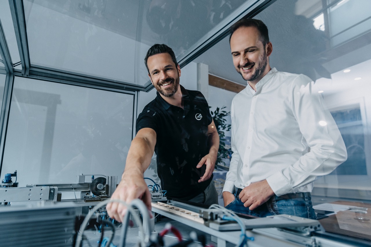 Zwei Kollegen besprechen das Modell einer Maschine.
