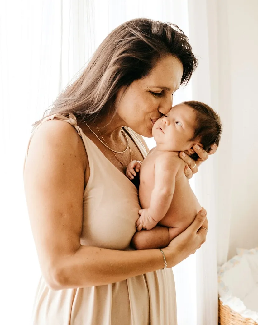 A woman holding a baby in her arms.