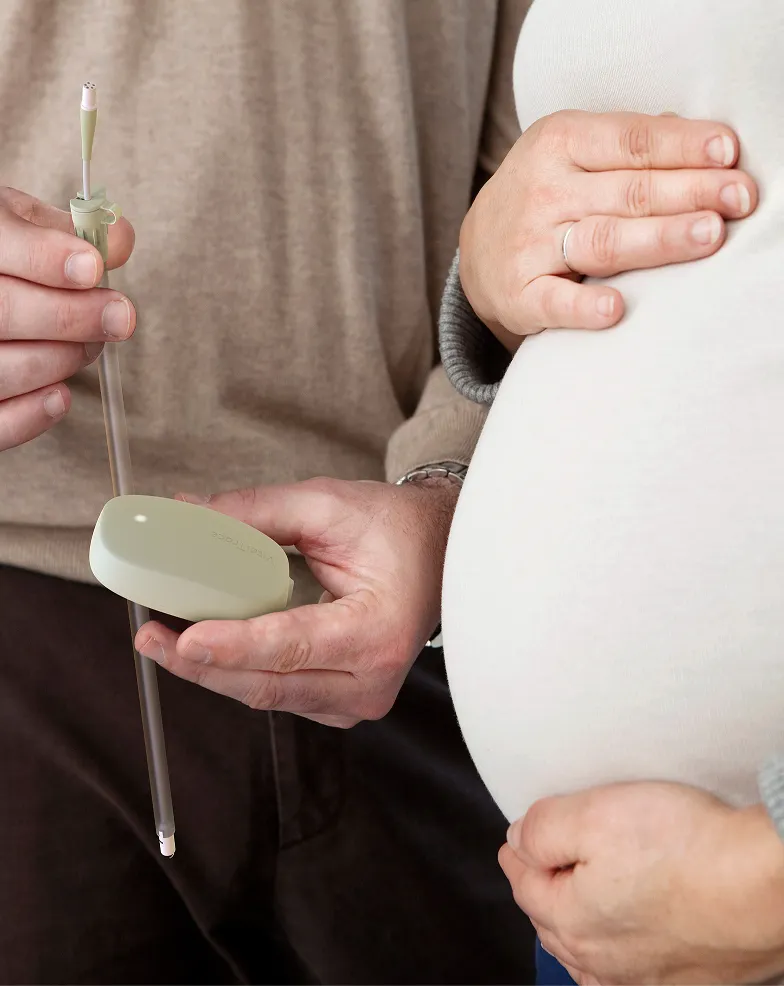 A pregnant woman holding a toothbrush in her hand.