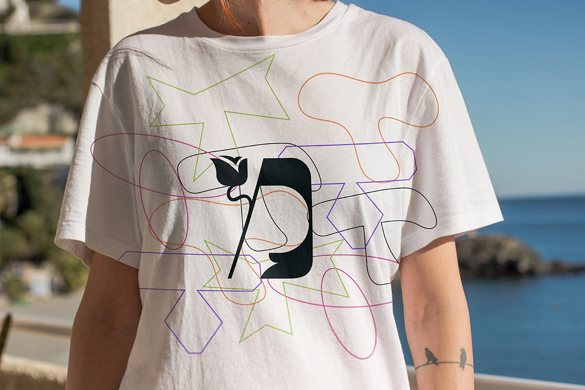 Mockup of a shirt demonstarting one of the letters from Kalamansa's fonts with shapes from the brand visual identity