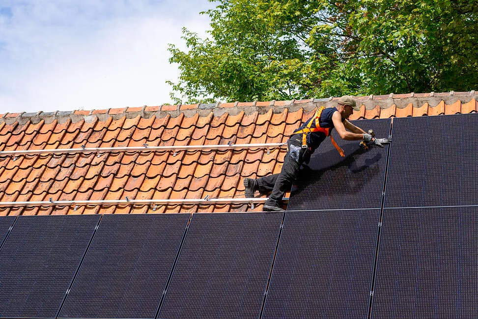 expert installeert zonnepanelen op dak