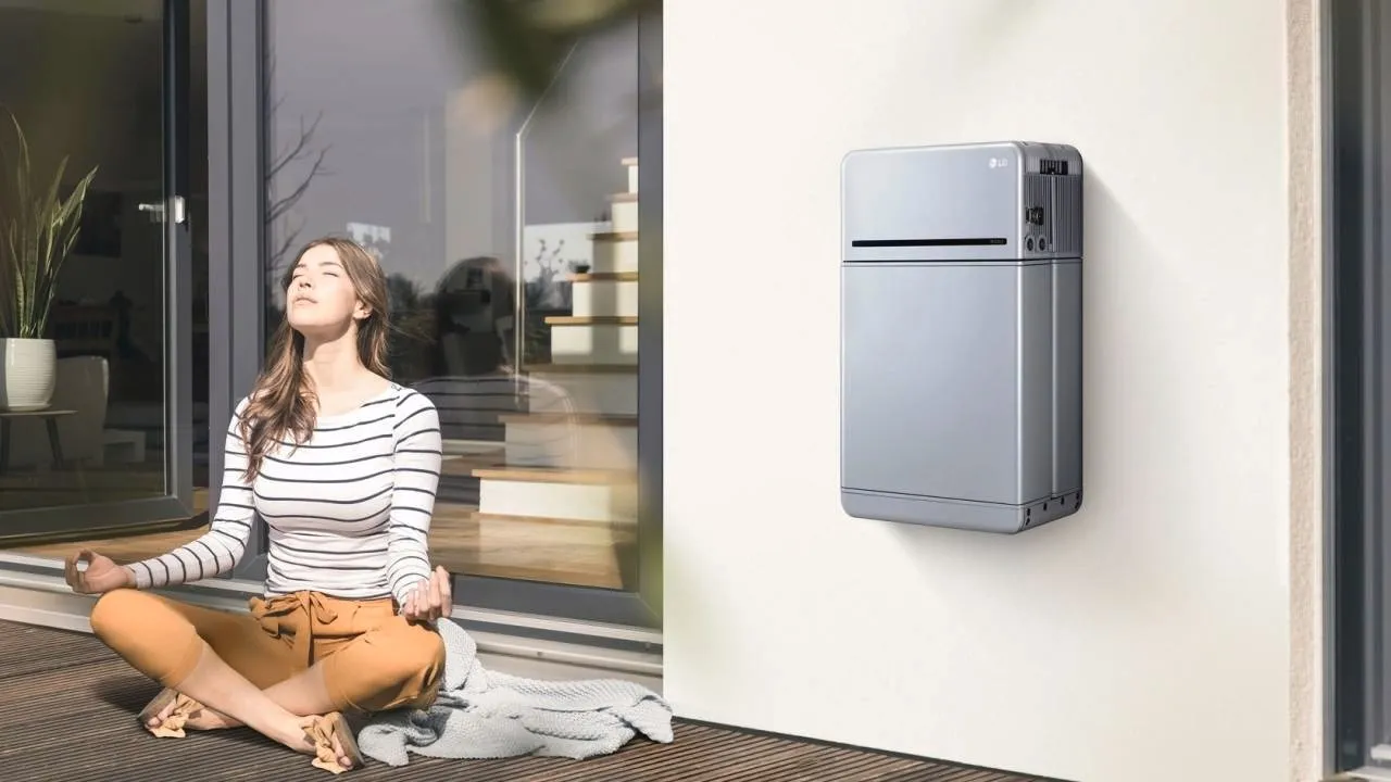 Vrouw ontspant naast een wandgemonteerde thuisbatterij van Energy Protect
