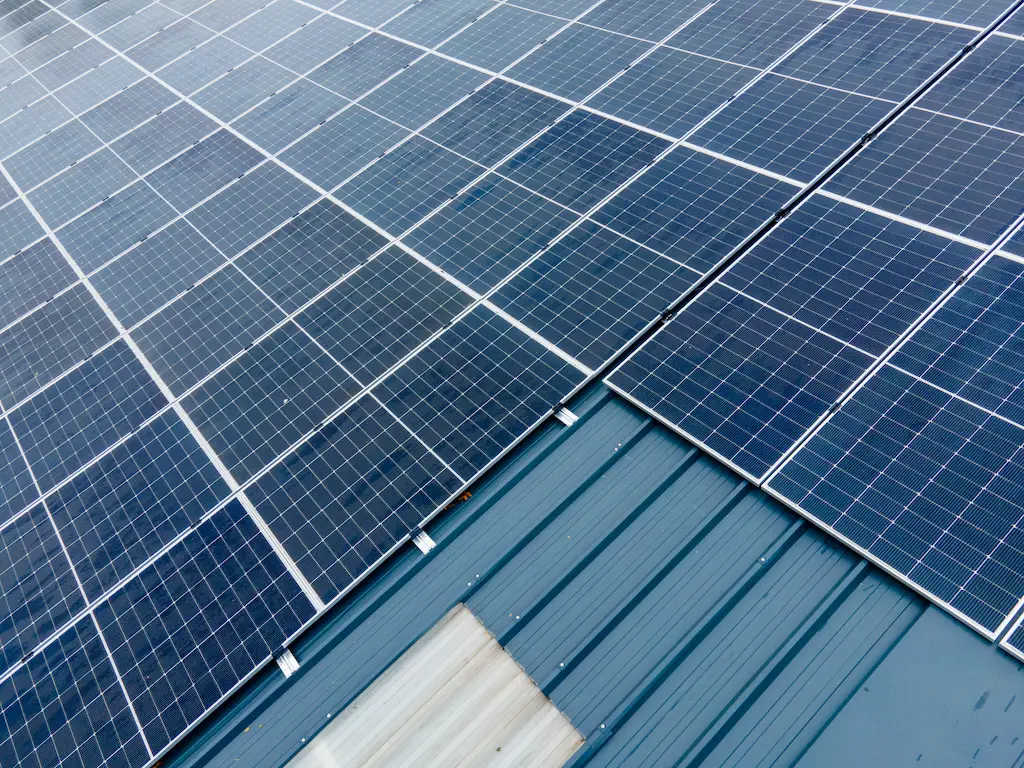 Gros plan sur des panneaux solaires haut de gamme et leur système de fixation sur une toiture industrielle, réalisé par Energy Protect.