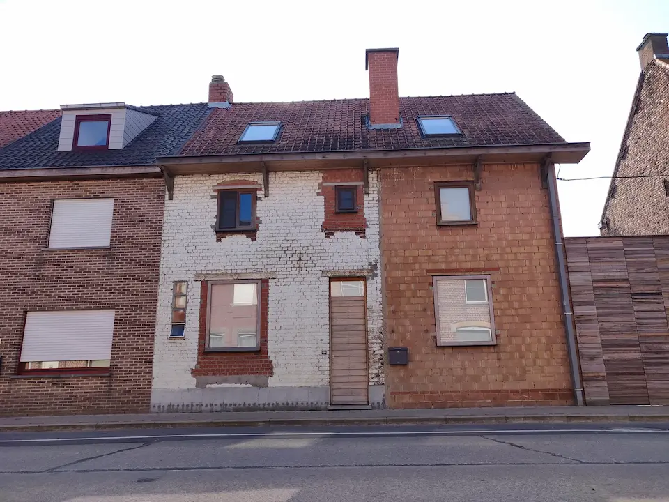 Oude rijwoning met verweerde bakstenen gevel en oude ramen
