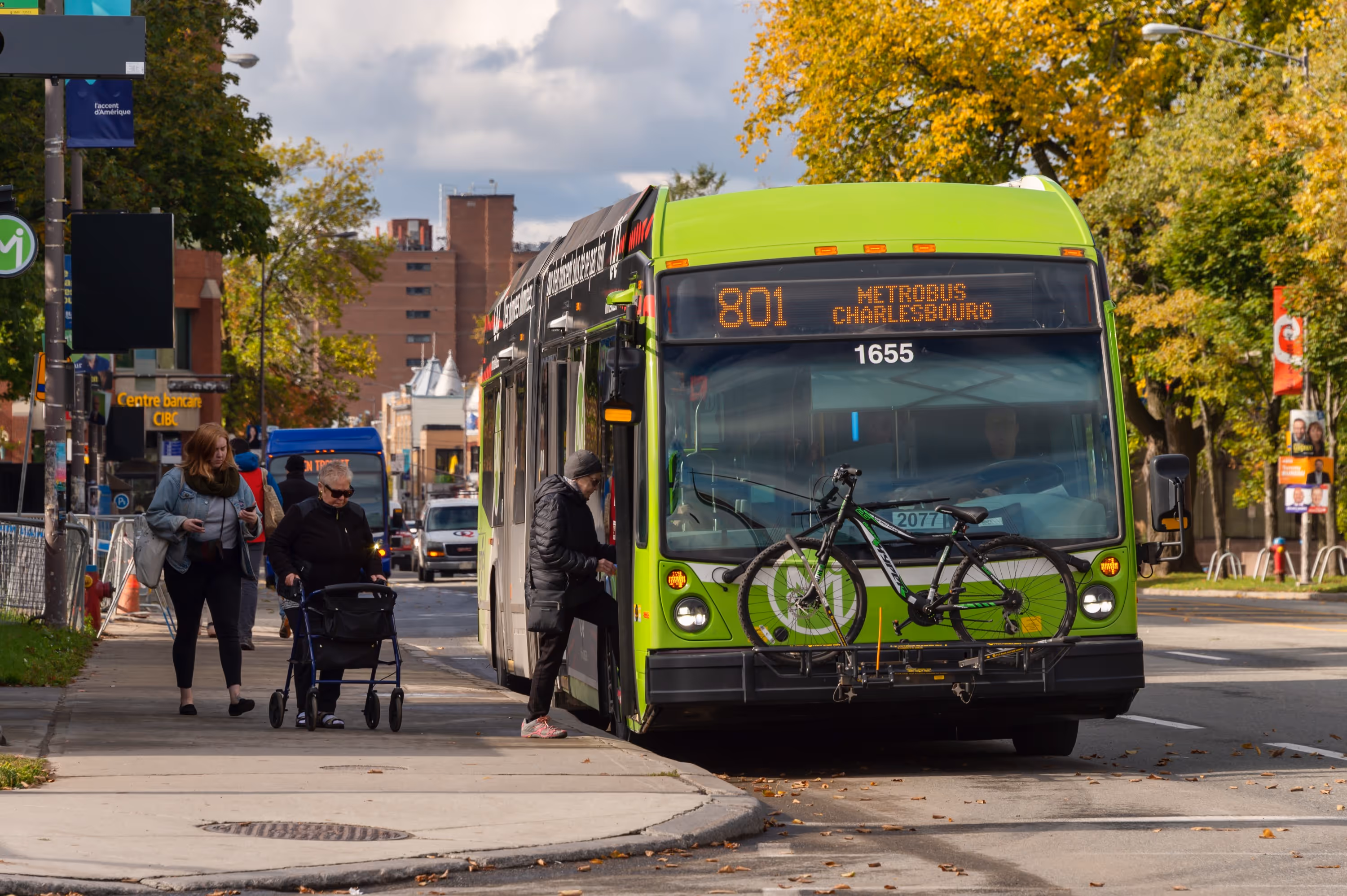 Métrobus vert avec un porte-vélos, un passager montant à bord.