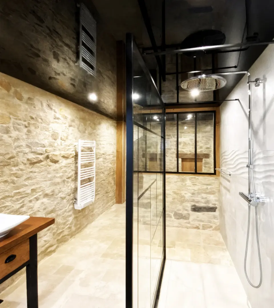 Salle de bain pierre naturelle, douche vitrée et plafond tendu noir effet miroir – Franche-Comté