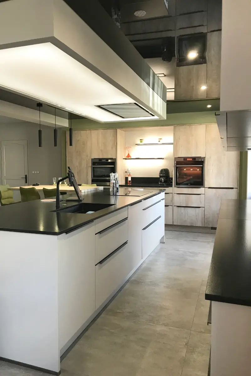 Vue rapprochée d'une cuisine moderne dans le 21, plafond tendu à luminosité variable au dessus de l'îlot central