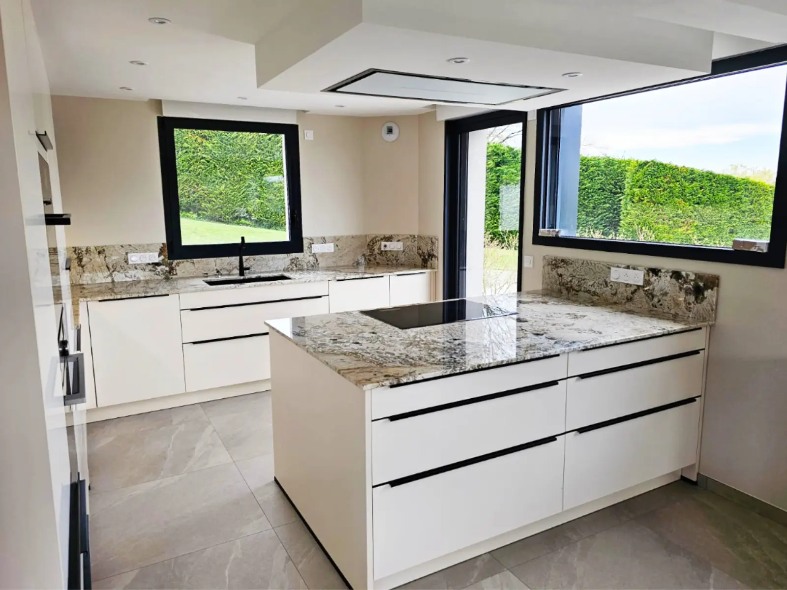 Cuisine lumineuse marbre blanc veiné brun, plans de travail sur-mesure – Jura