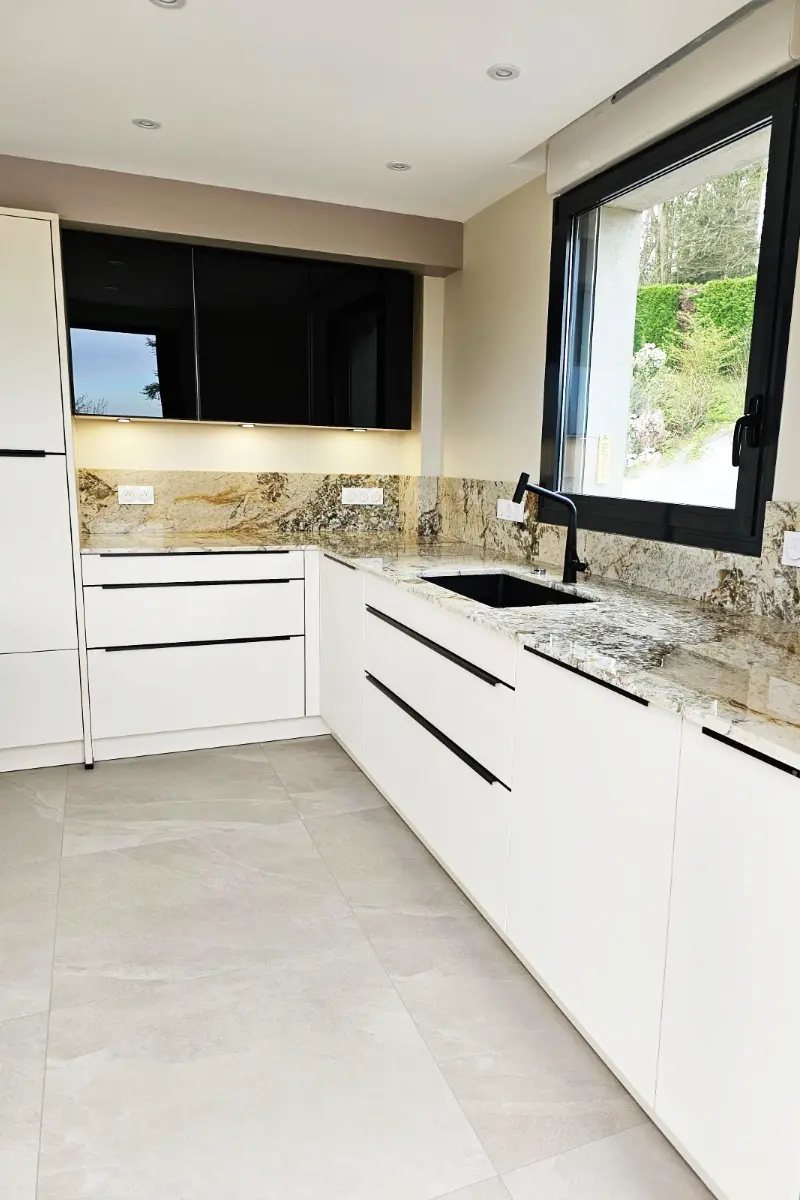 Une cuisine moderne, meubles haut en noir brillant, meubles bas en blanc mat