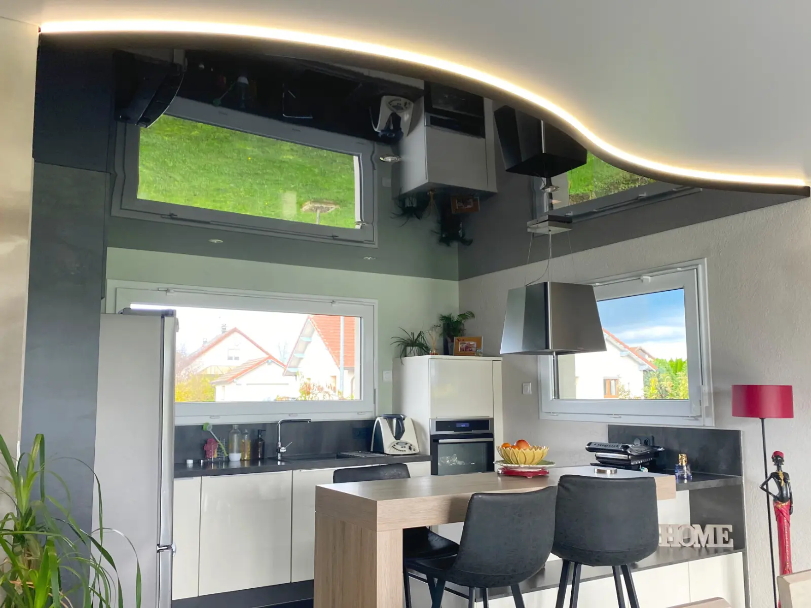 Plafond tendu effet vague au dessus d'une cuisine équipée et ouverte